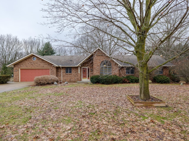 single story home with a garage, concrete driveway, and brick siding