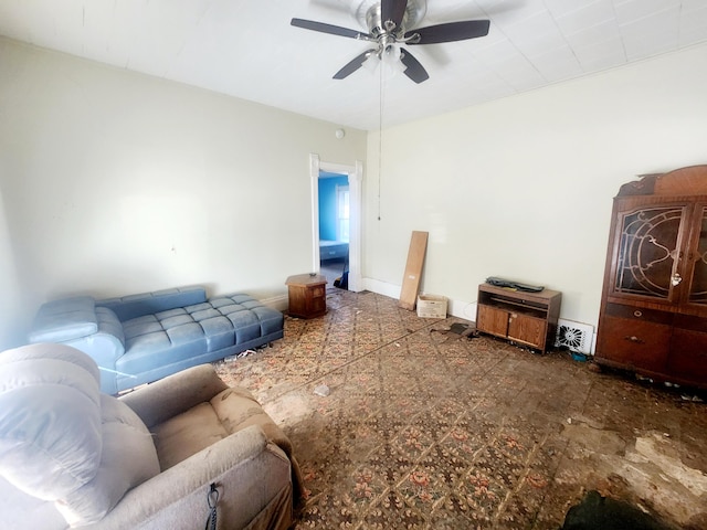 living area with baseboards and a ceiling fan