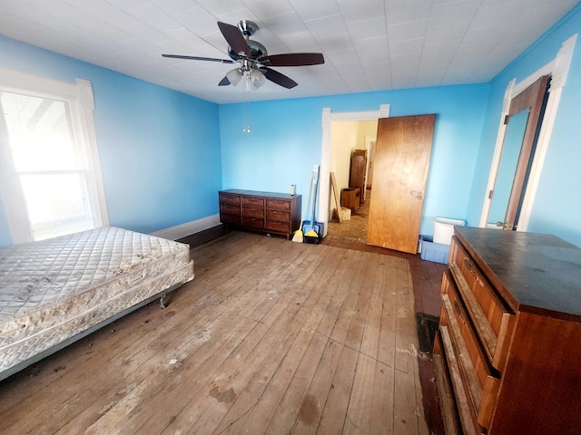 bedroom featuring a ceiling fan, baseboards, and hardwood / wood-style floors