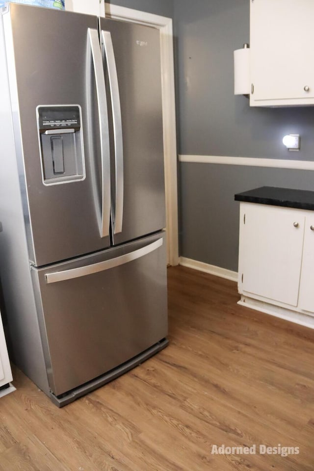 kitchen featuring white cabinetry, stainless steel fridge with ice dispenser, and light wood-type flooring