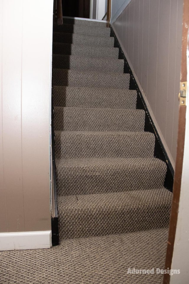 stairs featuring wood walls