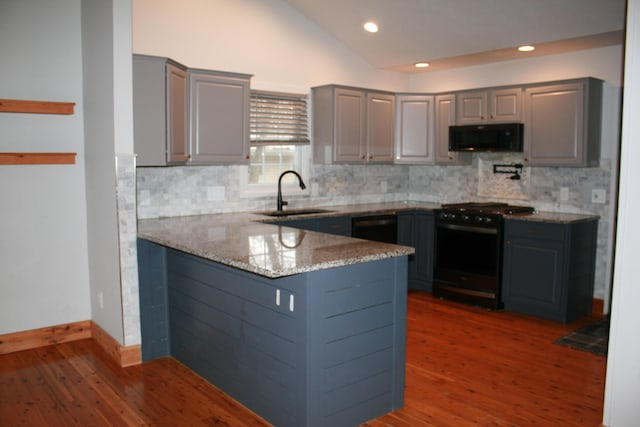 kitchen with black appliances, gray cabinetry, kitchen peninsula, light stone counters, and sink