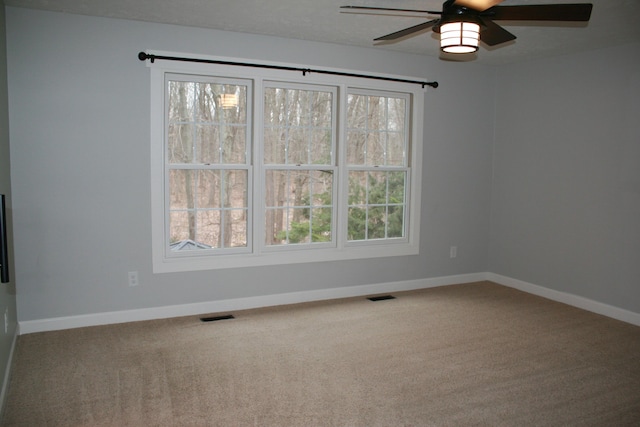 carpeted spare room with ceiling fan