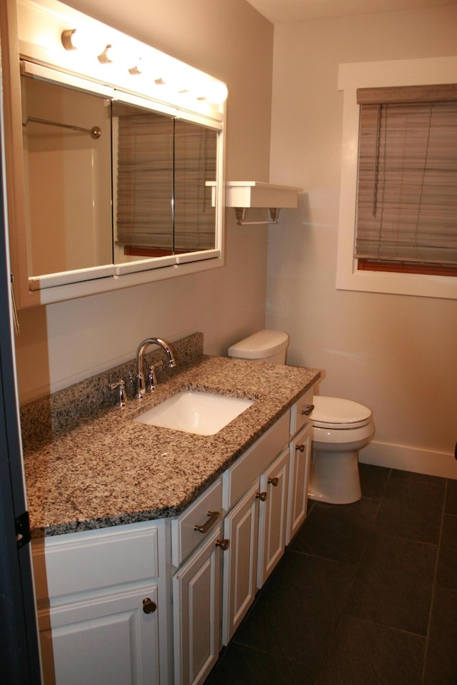 bathroom featuring toilet, tile patterned floors, and vanity