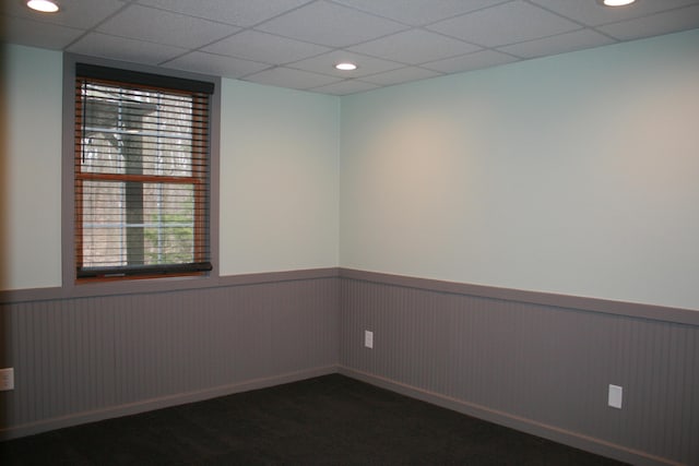 spare room featuring dark colored carpet