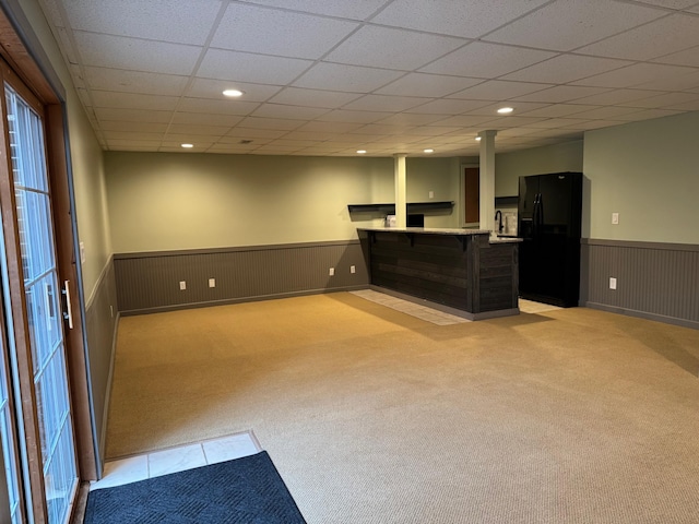 interior space with a paneled ceiling and light carpet