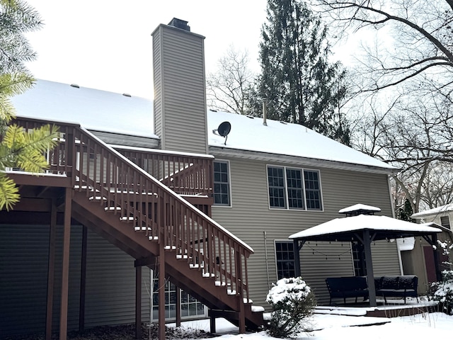 snow covered rear of property with a gazebo