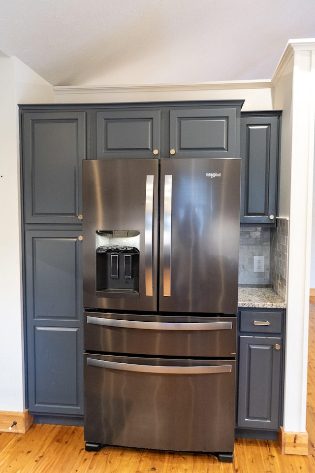 kitchen featuring crown molding, light hardwood / wood-style flooring, tasteful backsplash, light stone countertops, and stainless steel fridge with ice dispenser