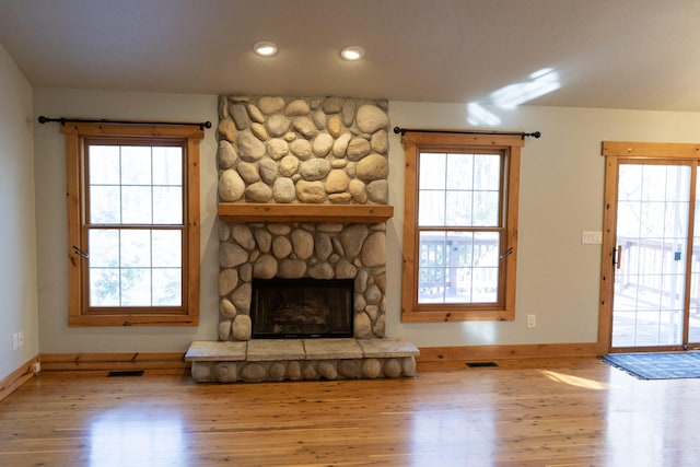 unfurnished living room featuring hardwood / wood-style flooring, a healthy amount of sunlight, and a fireplace