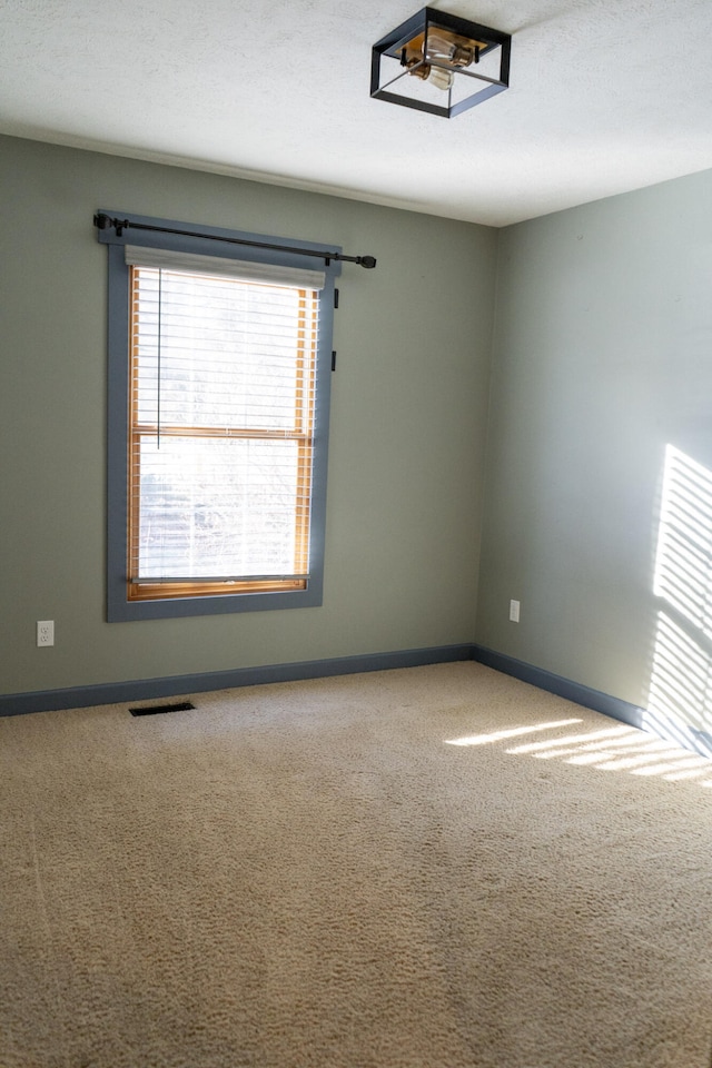 empty room with a textured ceiling and carpet