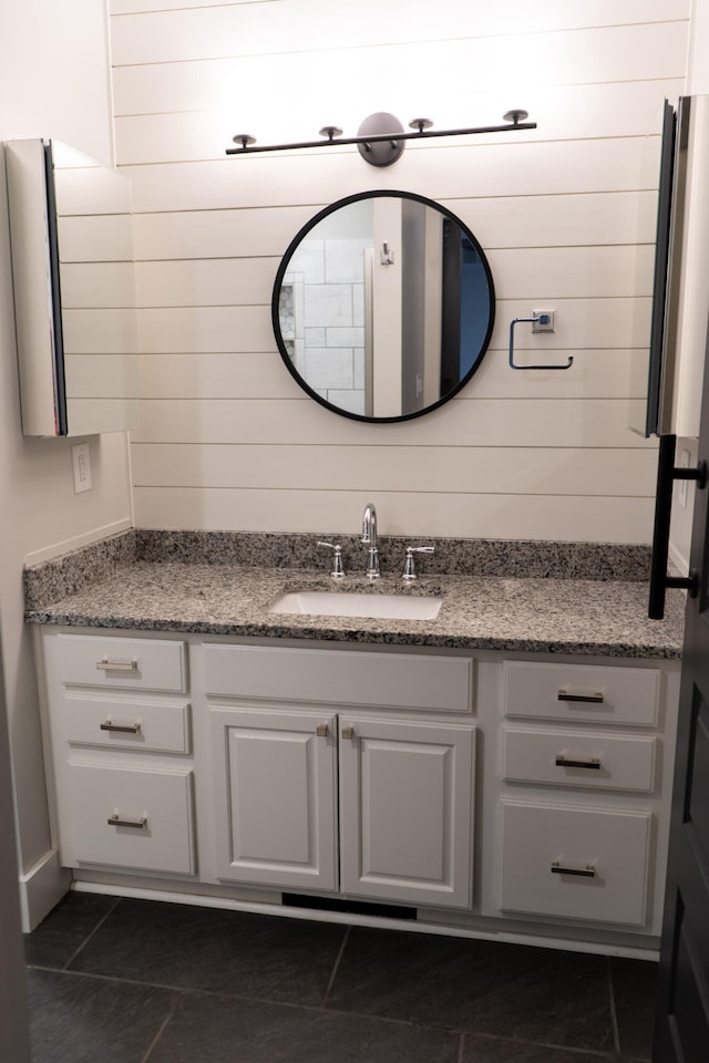 bathroom with vanity and wood walls