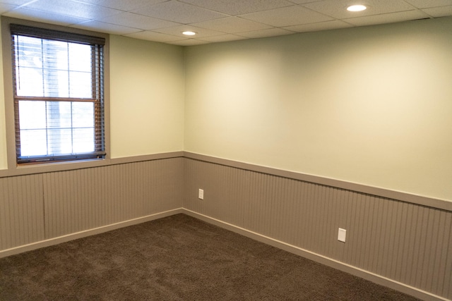 carpeted empty room featuring a paneled ceiling