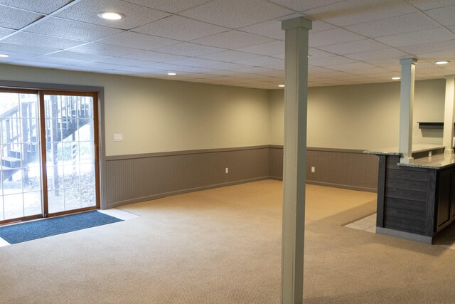 basement with light carpet and a paneled ceiling