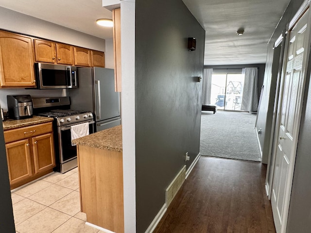 kitchen with light carpet and stainless steel appliances