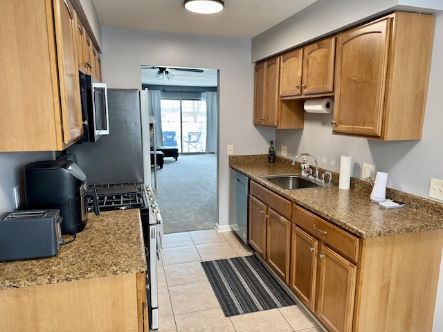 kitchen with light carpet, dark stone counters, stainless steel appliances, ceiling fan, and sink