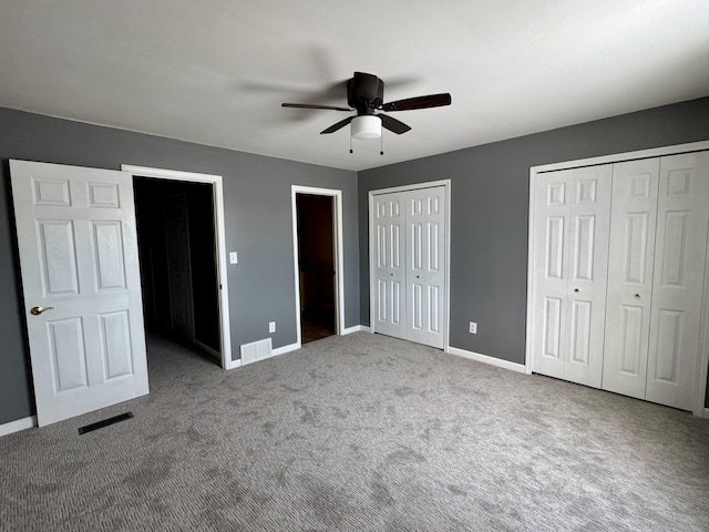 unfurnished bedroom with multiple closets, ceiling fan, and carpet floors