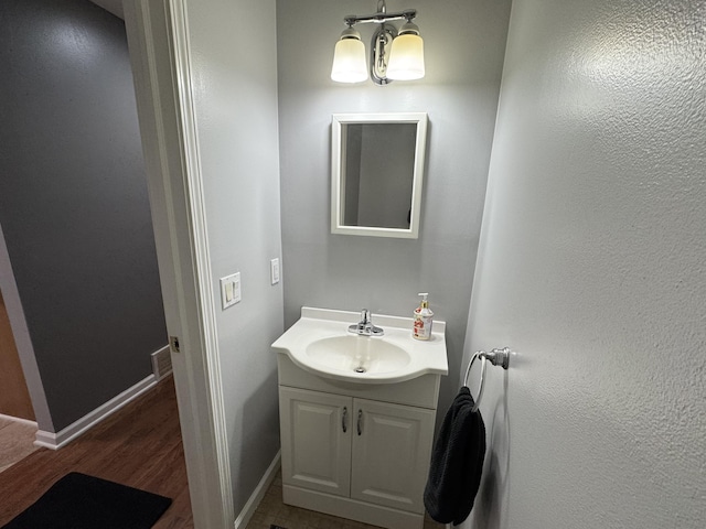 bathroom with a chandelier, vanity, and hardwood / wood-style flooring