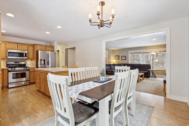 dining space featuring light hardwood / wood-style flooring and a notable chandelier