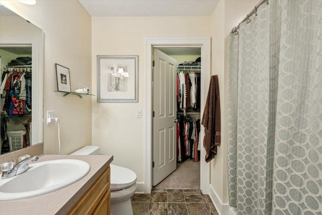 bathroom with vanity, curtained shower, and toilet