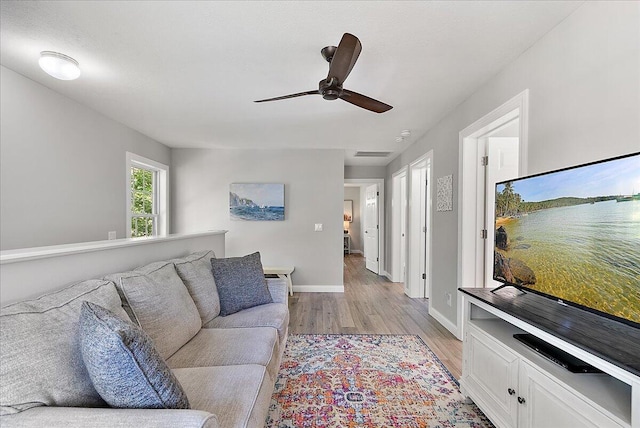 living room featuring ceiling fan and light hardwood / wood-style flooring