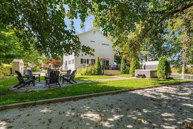 view of yard with a patio area, a jacuzzi, a shed, and a deck