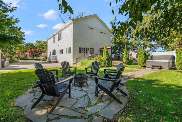 view of patio / terrace featuring a hot tub and an outdoor fire pit