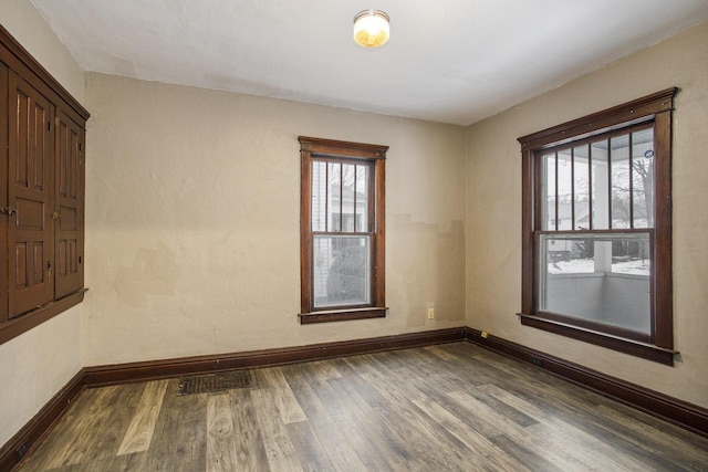 empty room with dark hardwood / wood-style flooring