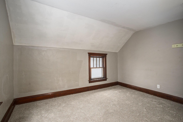 bonus room with lofted ceiling and carpet flooring