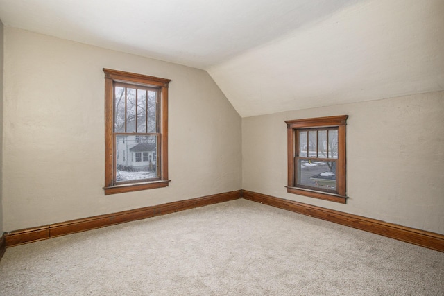 bonus room with lofted ceiling and carpet floors