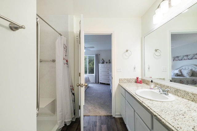 bathroom with hardwood / wood-style flooring, vanity, and walk in shower