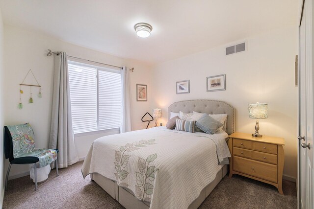 bedroom featuring dark carpet and multiple windows