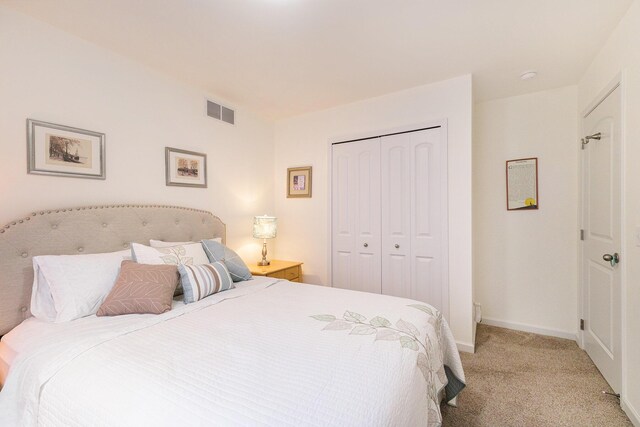 bedroom with light carpet and a closet