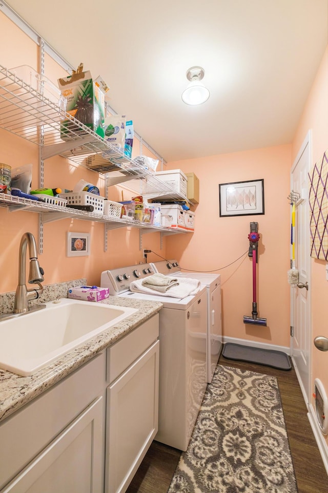 laundry area with independent washer and dryer, sink, and dark wood-type flooring