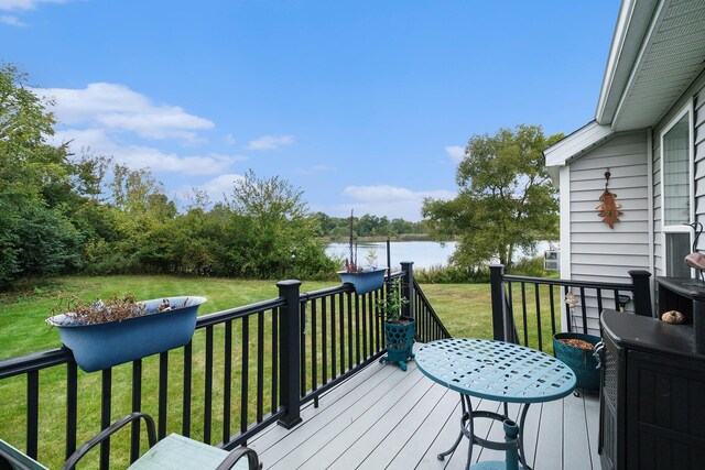 deck with a water view and a yard