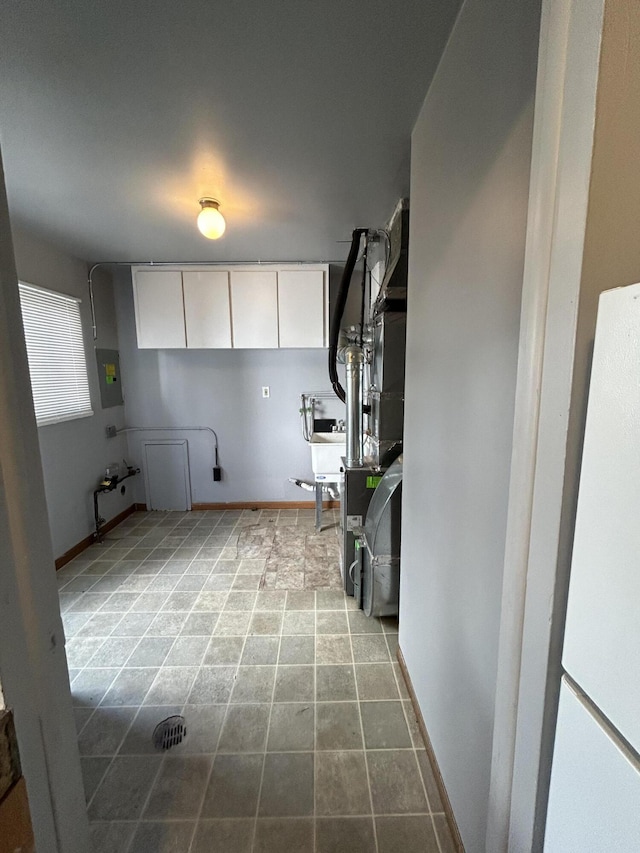 laundry area with cabinets and electric panel