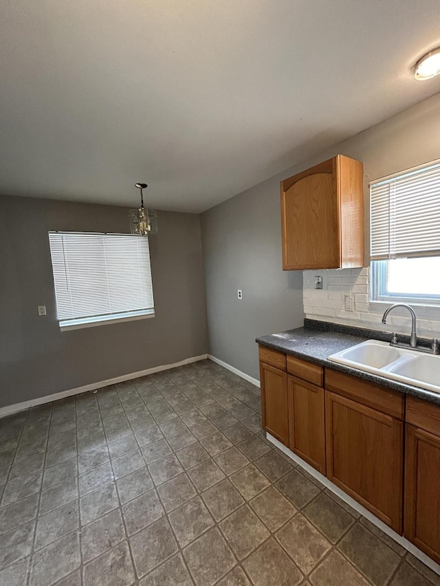 kitchen with sink, hanging light fixtures, and backsplash