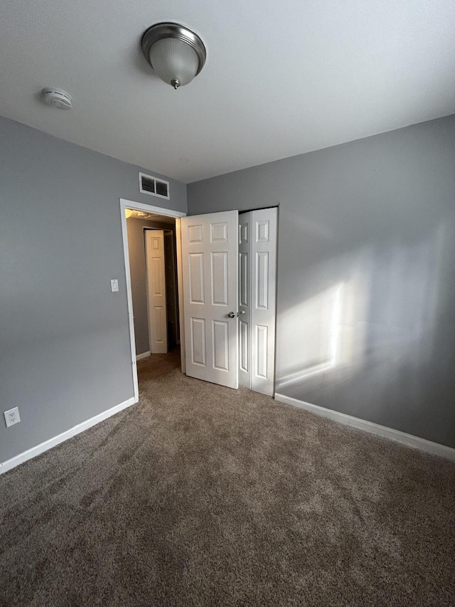 unfurnished bedroom featuring carpet flooring and a closet