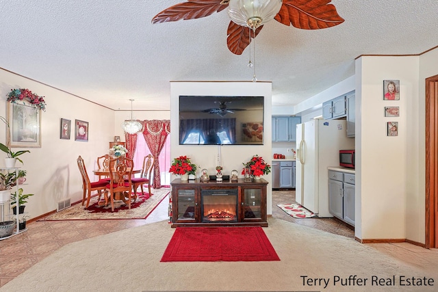 living room with a textured ceiling and ceiling fan