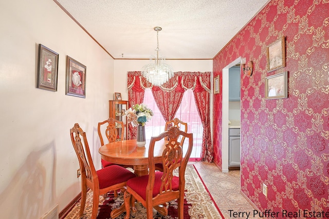 dining space with an inviting chandelier, ornamental molding, and a textured ceiling