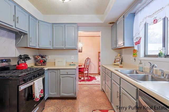 kitchen with stainless steel appliances, sink, and a textured ceiling