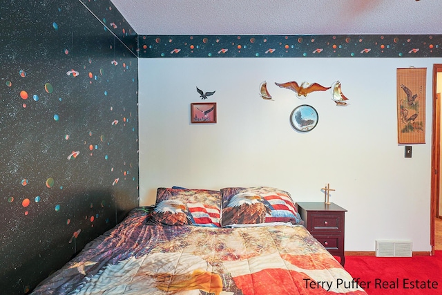 bedroom with carpet floors and a textured ceiling