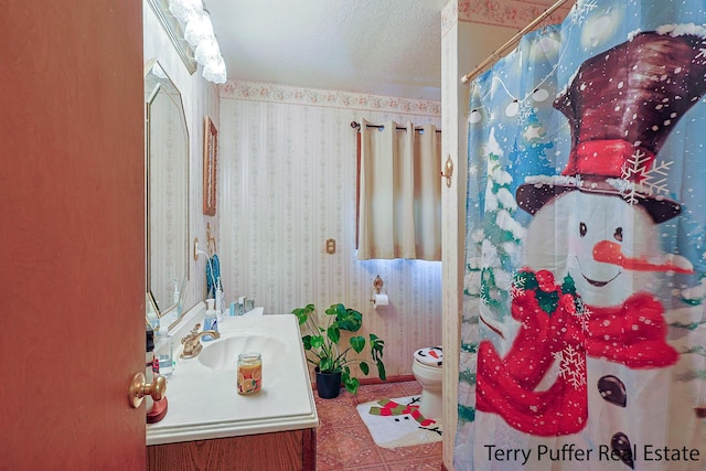 bathroom featuring vanity, toilet, tile patterned flooring, and a textured ceiling