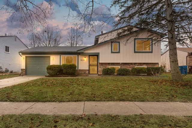 tri-level home featuring a yard and a garage