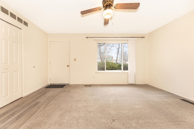 unfurnished room featuring ceiling fan and light colored carpet