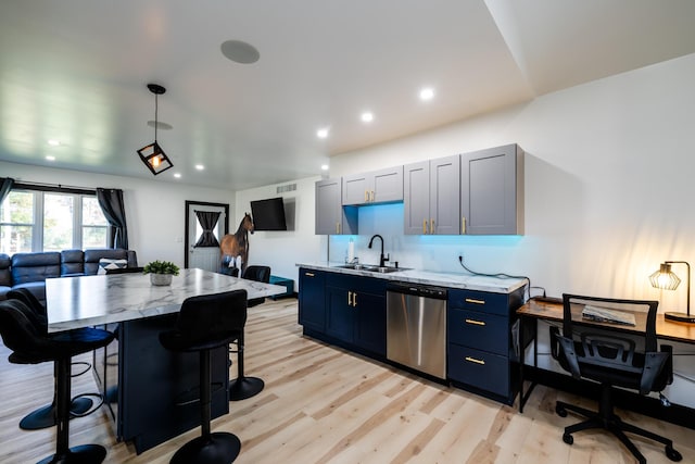 kitchen featuring sink, stainless steel dishwasher, light wood-type flooring, light stone counters, and a breakfast bar area