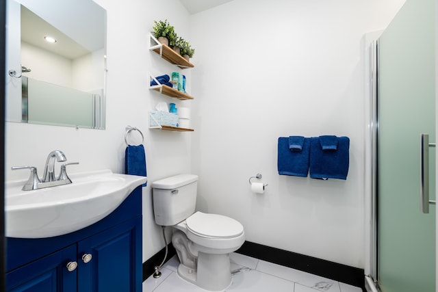 bathroom featuring tile patterned flooring, vanity, toilet, and walk in shower