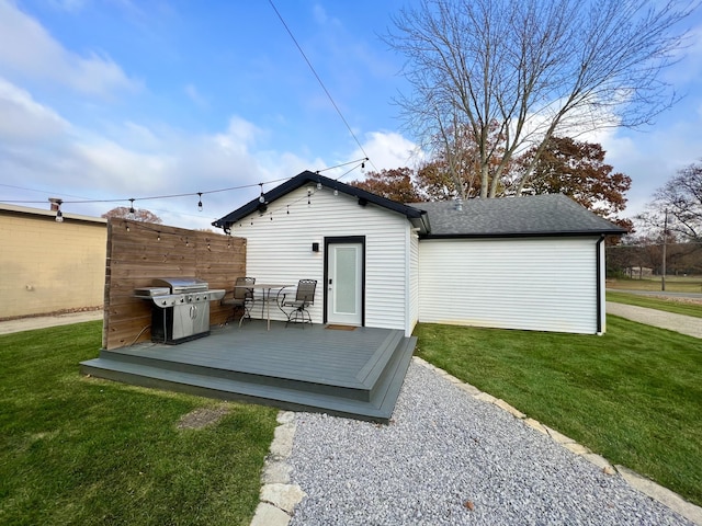 rear view of property featuring a lawn and a wooden deck