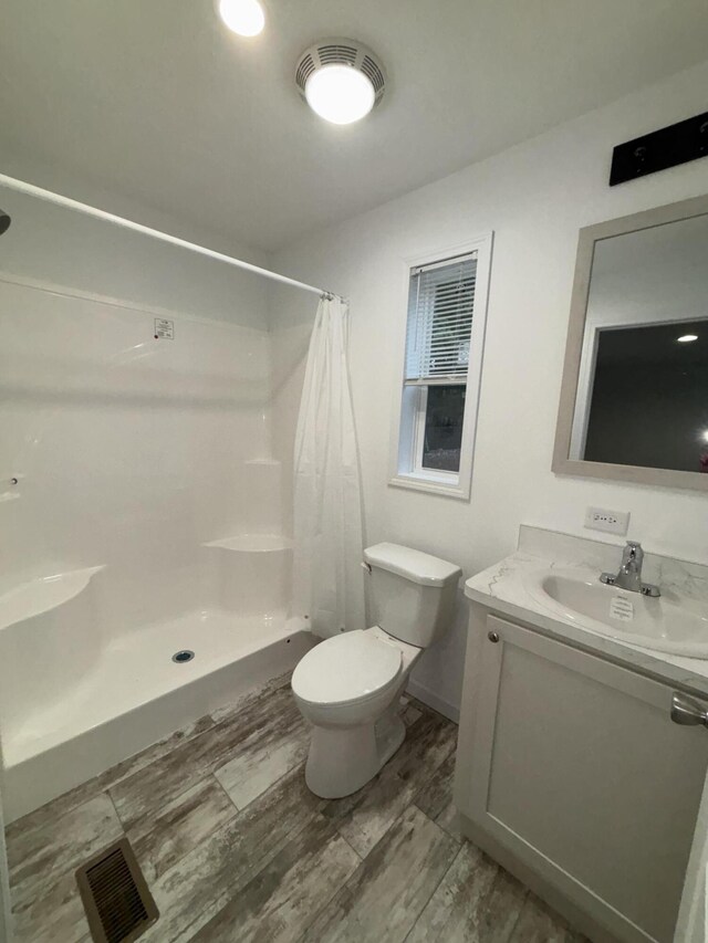 bathroom with toilet, vanity, and walk in shower