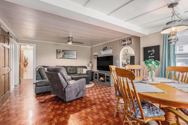 dining space with dark parquet flooring, ceiling fan, and ornamental molding