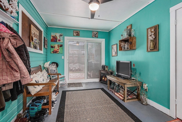 sitting room with ceiling fan and concrete floors